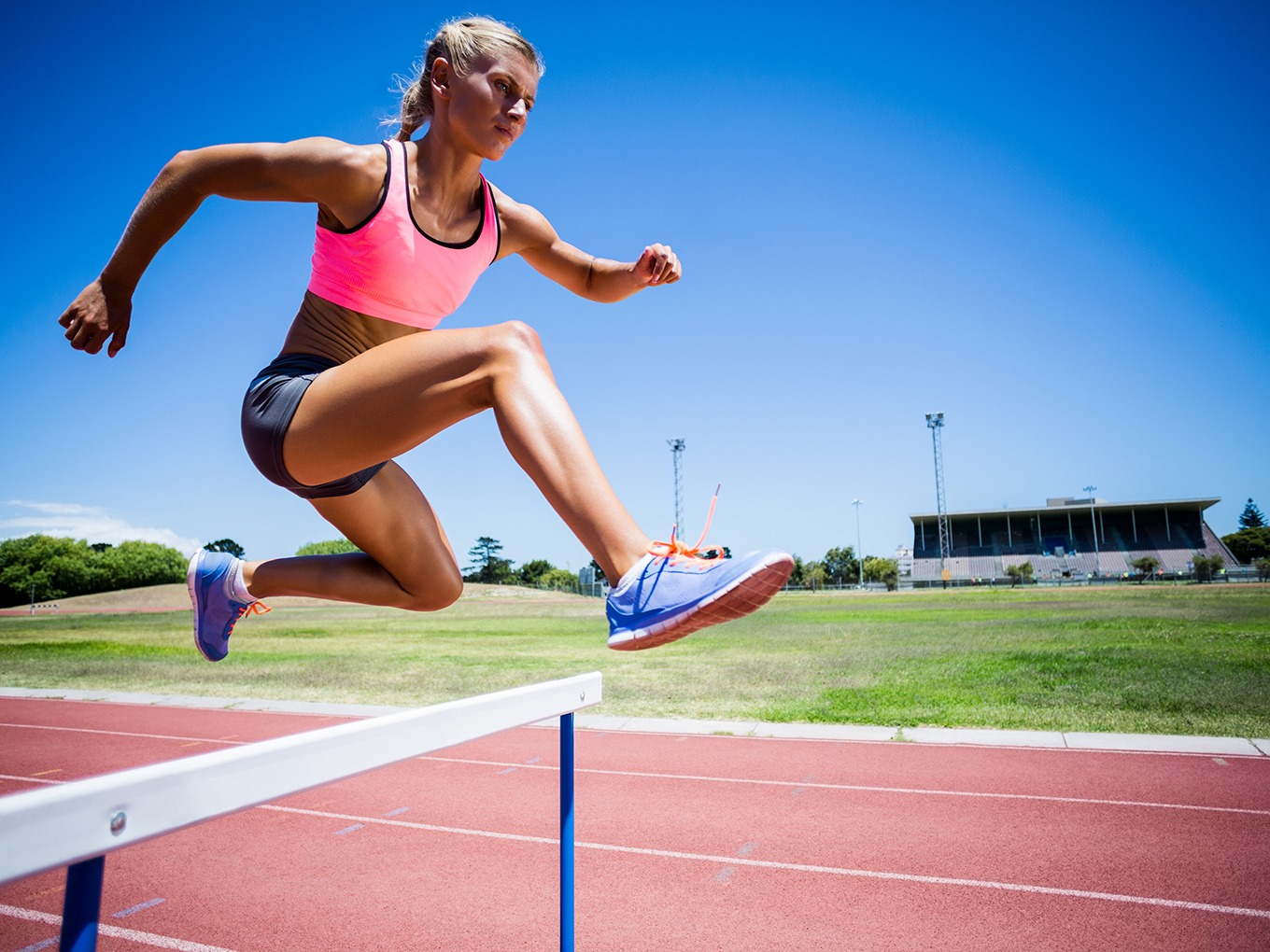 Approval Heroes - Navigating Industry Challenges A young female athlete jumping over a hurdle