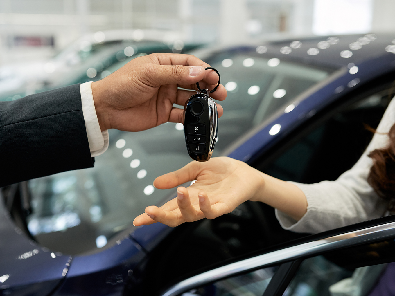 Trust and transparency in car-buying with Approval Heroes A car salesperson giving the keys to a customer