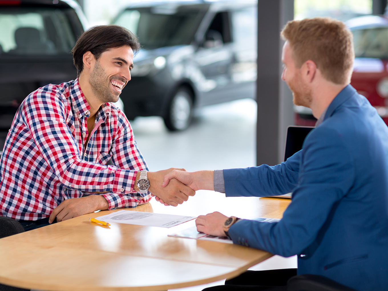 Positive car-buying experience with Approval Heroes - Happy customer and dealer shaking hands Happy customer shaking hands with a dealer after buying a car
