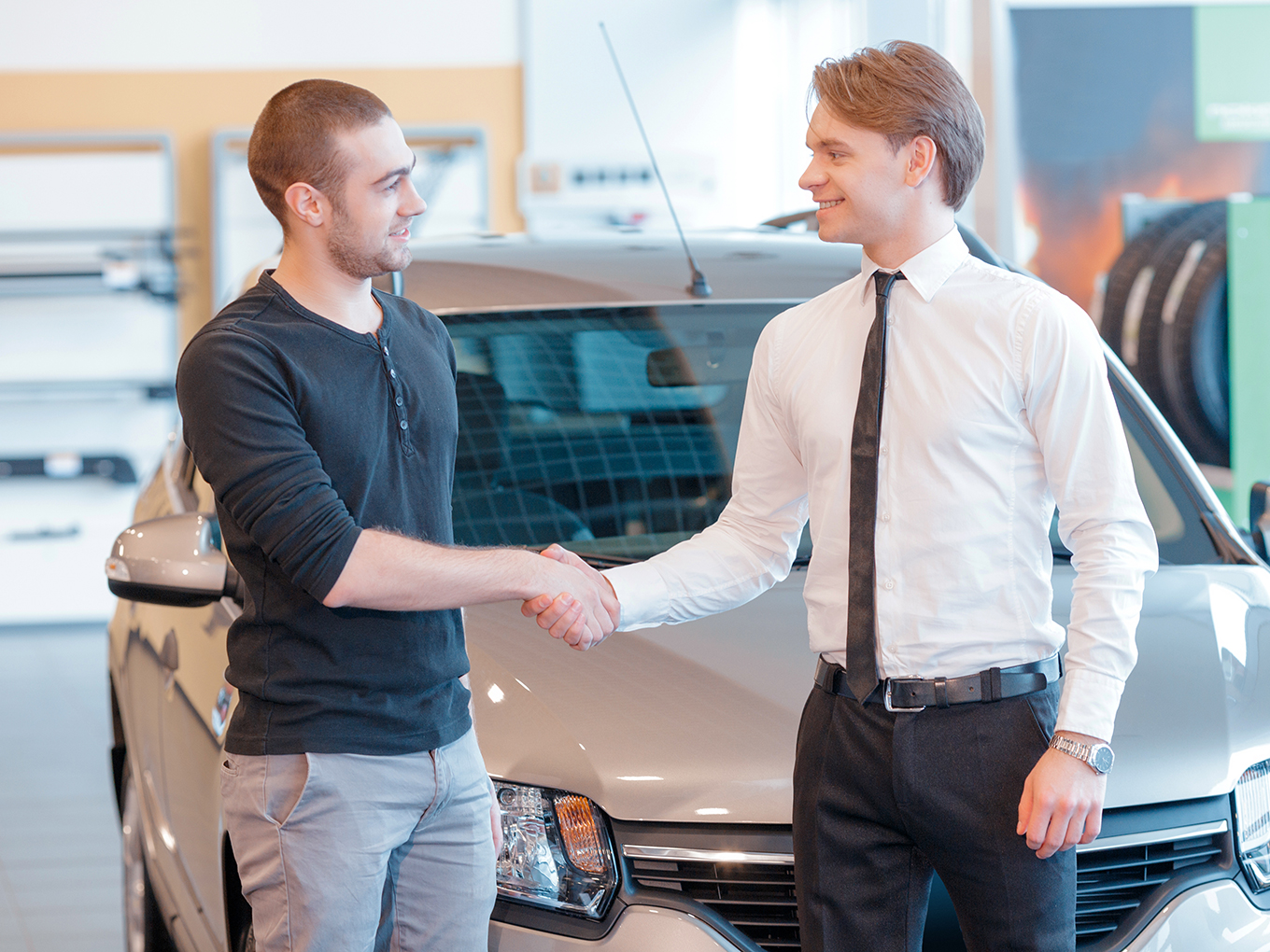 A car shopper shaking hands with a trustworthy car dealer, representing Approval Heroes' commitment to connecting car shoppers with reputable dealerships and a safe car-buying experience