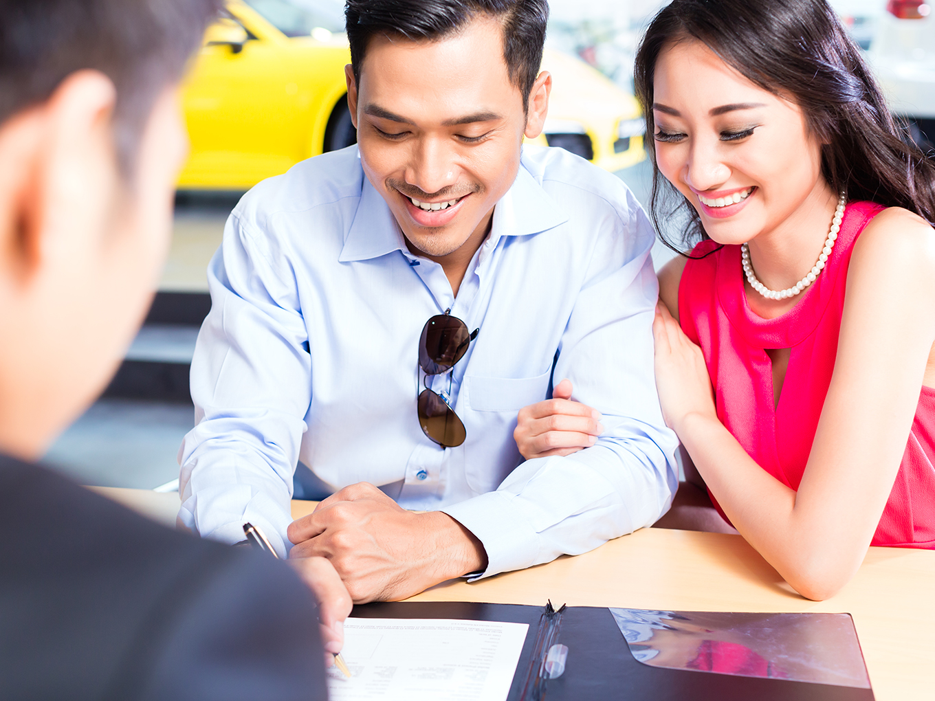 Signing Sales Contract for Car at Dealership Couple signing sales contract for car at dealership