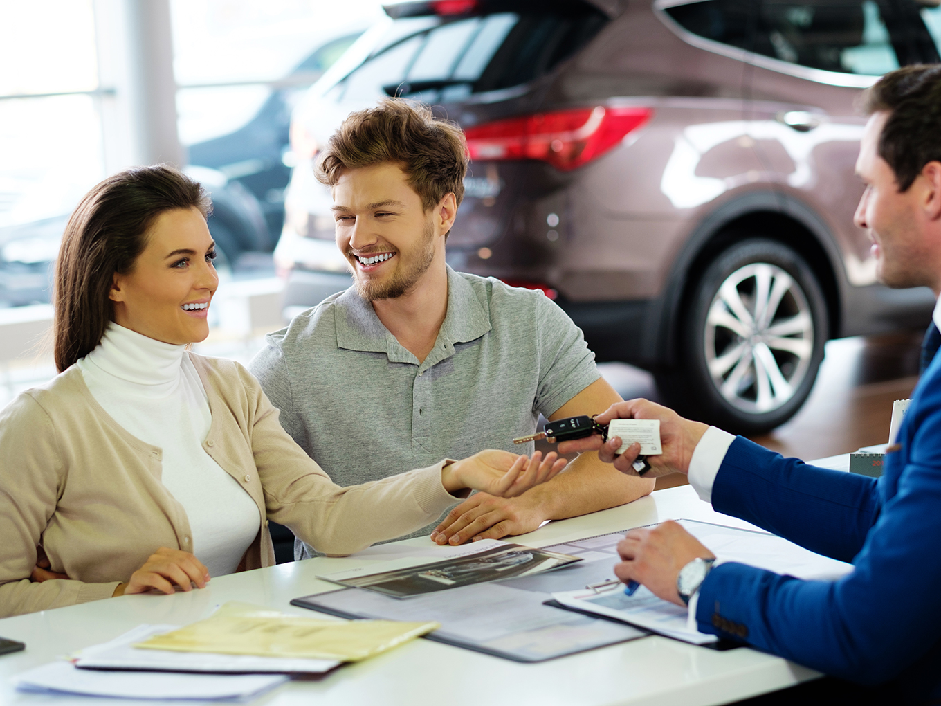 A joyous young couple receives the keys to their new vehicle, courtesy of Approval Heroes' easy and reliable used car loan service. Start your own journey today with Approval Heroes.